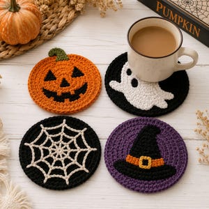 May include: Four round crochet coasters featuring Halloween designs: an orange jack-o'-lantern, a white ghost on a black background, a white spiderweb on a black background, and a black witch hat with an orange band on a purple background.