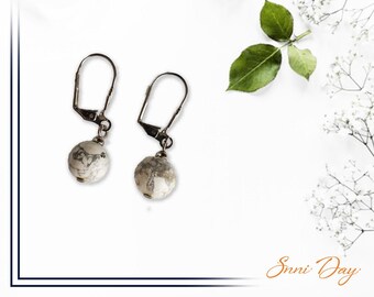 Pendientes de piedra de ágata en blanco y negro con cierre trasero de palanca plateada.