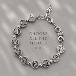 May include: A silver-toned chain bracelet featuring a series of circular religious medals and small round beads. The bracelet includes a lobster claw clasp and an adjustable extender chain. The text CHOOSE ALL THE MEDALS is centred.