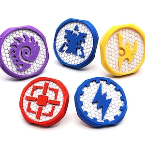 May include: Five circular tokens with a white hexagonal grid background. Each token features a distinct raised symbol in purple, blue, yellow, red, or dark blue. The tokens have colored borders and are arranged in a group on a plain white surface.