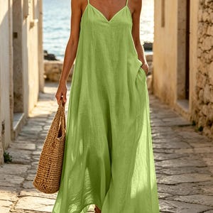 Pu&ograve; includere: Un abito lungo color verde lime con scollo a V, spalline sottili e una silhouette ampia e fluida che arriva alle caviglie. L'abito presenta tasche laterali ed &egrave; abbinato a una borsa tote in paglia intrecciata color marrone chiaro.
