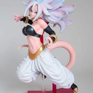 May include: A collectible anime figure of a character with long, flowing light pink and blue hair, wearing a black strapless top, black arm sleeves with gold cuffs, and white baggy trousers with a gold waistband, standing on a red base.