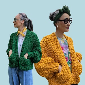 May include: Two women model chunky knit cardigans. One is emerald green, the other is mustard yellow. Both have large pockets and are buttoned. The word "PATTERN" is displayed at the top of the image.