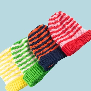 Op de afbeelding: Vier gestreepte gebreide mutsen in verschillende kleurencombinaties: rood en roze, donkerblauw en oranje, groen en wit, en geel en wit.