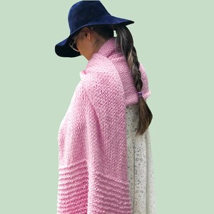 May include: A DIY KIT text graphic above a dark blue wide-brimmed hat and a chunky knit light pink scarf. The scarf features a textured ribbed pattern at the bottom edge and is draped over a white lace garment. The overall composition is clear.