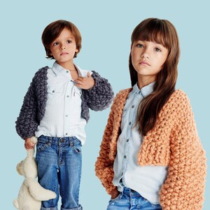 May include: Two children wearing chunky knit boleros. One bolero is a dark gray color, and the other is a peach color. The children are wearing denim shirts and jeans. The word "PATTERN" is in a white box at the top of the image.