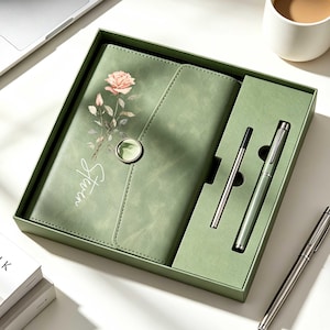 May include: A sage green stationery gift set in a matching box, featuring a notebook with a rose illustration and the word "Stern" printed on the cover, a circular magnetic closure, a matching pen, and an additional ink refill cartridge.
