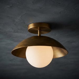 Plafoniera moderna in ottone semi-incasso con globo in vetro opalino.