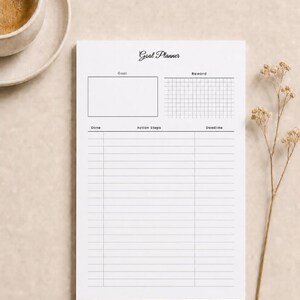 May include: A white goal planner sheet with black text and lines. The header reads Goal Planner. It includes sections for Goal, Reward, Done, Action Steps, and Deadline. The layout features a large rectangular box, a grid, and multiple horizontal rows.