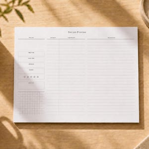 May include: A white rectangular recipe planner notepad with black text and lines. The header reads Recipe Planner, with sections for prep time, cook time, servings, yield, a five-star rating, a grid area, ingredients, and directions.