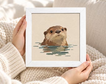 Puede incluir: Un marco cuadrado blanco que contiene una pintura de una nutria marrón con ojos oscuros y bigotes, mostrada desde el pecho hacia arriba emergiendo del agua. El fondo de la obra es de un color beige claro sólido con texturas de pinceladas.
