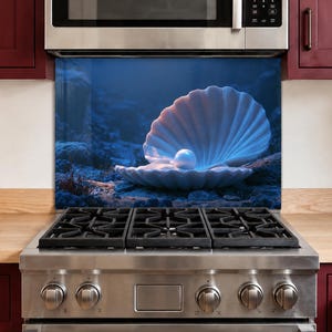 May include: A rectangular kitchen splashback panel featuring a high-resolution underwater scene of a large, open white seashell resting on the dark ocean floor, cradling a single, glowing, spherical white pearl amidst deep blue, shadowy water.