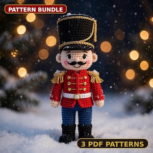 May include: A crocheted nutcracker doll featuring a black hat with gold trim, a red jacket with gold buttons and fringe epaulets, a white belt, and blue trousers. The text PATTERN BUNDLE and 3 PDF PATTERNS is visible on the image.