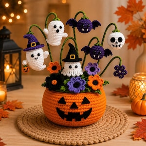May include: A crocheted Halloween arrangement featuring a bright orange jack-o'-lantern base with a black face. The display includes white ghosts, purple bats, a skull, and colourful flowers on green stems, all crafted with detailed yarn textures.