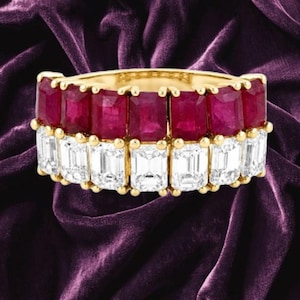 Puede incluir: Un anillo de oro con dos filas horizontales de piedras preciosas. La fila superior consta de siete rubíes de color rojo intenso con corte esmeralda, mientras que la fila inferior presenta siete diamantes blancos transparentes con corte esmeralda.
