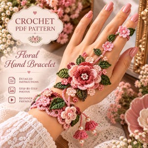 May include: A crochet PDF pattern for a floral hand bracelet featuring pink and dark green yarn flowers, leaves, and small white beads. The design includes a wrist cuff connected to a finger ring with floral motifs and dangling bell-shaped accents.