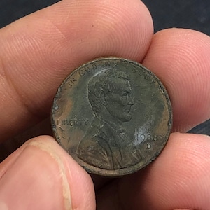 Puede incluir: Una moneda de un centavo Lincoln de 1988 D con el perfil de Abraham Lincoln mirando hacia la derecha. La moneda de color cobre muestra el texto IN GOD WE TRUST en la parte superior, LIBERTY a la izquierda y el año 1988 con la marca D a la derecha.