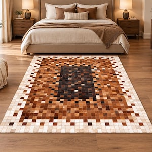 May include: A rectangular area rug featuring a pixelated mosaic pattern composed of small square patches in varying shades of brown, tan, cream, and black. The design transitions from a dark central rectangle to lighter tones toward the edges.
