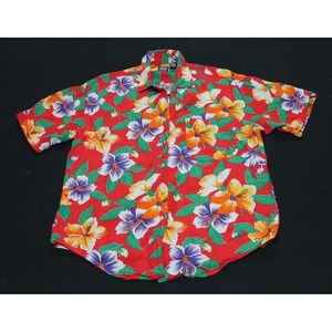 May include: A short-sleeved button-down shirt in a vibrant red color featuring an all-over floral print with yellow, orange, purple, and white hibiscus flowers and green leaves. The shirt includes a collar, a front pocket, and a Gap brand label.