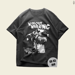 May include: A charcoal gray short-sleeve t-shirt featuring a white graphic of a snarling dog. The text "WITHOUT WARNING" appears above the dog, with "BY OFFSET 21 SAVAGE METRO BOOMIN" printed below. A circular "DG M" logo is visible in the bottom right.