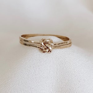 May include: A gold knot ring with a hammered finish. The ring is simple and elegant, and would make a great gift for a special occasion.