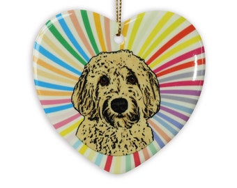 May include: A heart-shaped ceramic ornament with a colorful rainbow design and a brown and white doodle dog in the center.