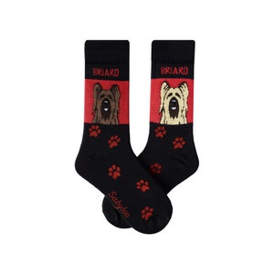 May include: A pair of black socks with a red and white design featuring a Briard dog breed. The socks have paw prints and the word "Briard" on them. The socks are made by the brand "Sabytoo".