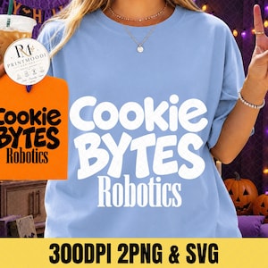 May include: A light blue t-shirt featuring the white text Cookie BYTES Robotics printed on the front. The design uses a bold, rounded font for the words Cookie and BYTES, with the word Robotics in a thinner, serif font below them.