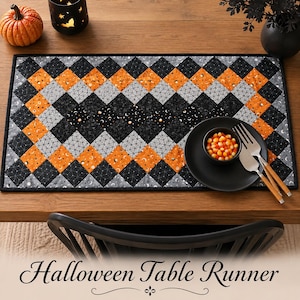May include: A rectangular quilted table runner featuring a diamond pattern in black, orange, and gray fabrics. The design includes various Halloween-themed prints such as moons, stars, and spiderwebs. The runner has a black border and binding.