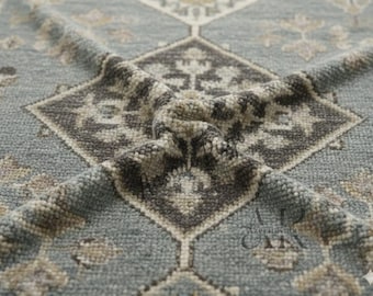 May include: A light blue rug featuring a repeating geometric diamond pattern in dark grey and beige. The textured surface displays intricate floral motifs within each diamond shape. The logo AK Azechi Knots is visible in the bottom right corner.