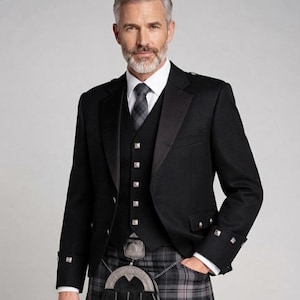 May include: A black wool jacket with satin lapels and silver buttons, worn over a matching black waistcoat with silver buttons, a white collared shirt, a grey plaid necktie, and a grey plaid kilt with a black leather sporran featuring silver accents.
