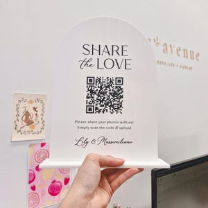 May include: A white sign with an arched top, displaying "SHARE the LOVE" and a QR code. Underneath, it says "Please share your photos with us! Simply scan the code & upload." The sign is signed "Lily & Massimiliano."