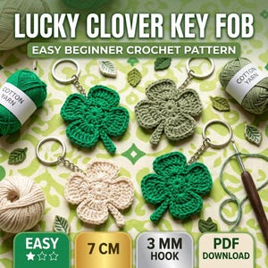 May include: LUCKY CLOVER KEY FOB EASY BEGINNER CROCHET PATTERN. Four crocheted clover keychains in bright green, sage green, and cream colors with metal rings. Includes yarn skeins, a crochet hook, and text labels indicating 7 CM and 3 MM HOOK.