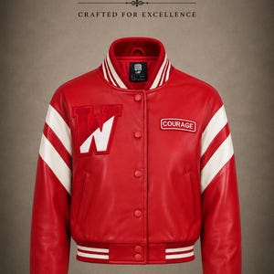 Op de afbeelding: Een rood varsity-jack met witte strepen op de mouwen, een grote witte letter W-patch op de rechterborst en een rechthoekige patch met het woord COURAGE op de linkerborst, voorzien van een sluiting met drukknopen en geribbelde boorden.