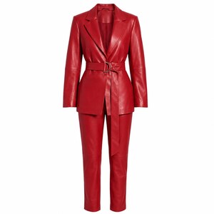 Op de afbeelding: Een felrood leren pak bestaande uit een blazer met lange mouwen en een bijpassende broek. De blazer heeft een ingekeepte revers, gestructureerde schouders en een bijpassende rode leren riem met een goudkleurige metalen D-ring gesp.