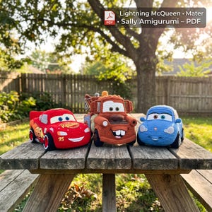Può includere: Tre giocattoli amigurumi all'uncinetto che raffigurano le auto Lightning McQueen in rosso, Mater in marrone e Sally in azzurro. L'auto rossa presenta il numero 95 e la scritta Rust-eze. Un'etichetta digitale riporta Lightning McQueen, Mater, Sally Amigurumi - PDF.