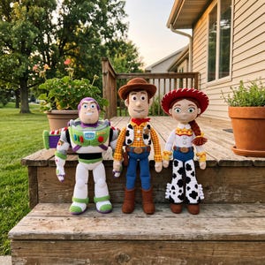 May include: Three handmade crochet dolls representing space ranger and cowboy characters. The space ranger features a white, green, and purple suit. The two cowboy figures wear brown hats, yellow shirts with vests, blue pants, and brown boots.