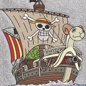 May include: An embroidered patch on a gray textured fabric featuring a brown pirate ship with a white sail. The sail displays a skull and crossbones wearing a yellow straw hat. A ram figurehead is at the bow, and a small black flag flies above.