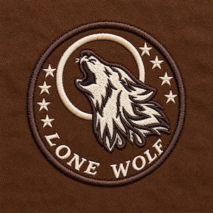 Op de afbeelding: Een ronde geborduurde patch op een bruine stoffen achtergrond met een huilende wolvenkop in wit en donkerbruin garen. Het ontwerp bevat een witte cirkelvormige rand, zeven kleine witte sterren en de tekst LONE WOLF in witte letters.