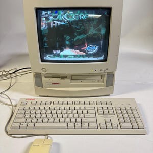 May include: A beige Compaq Presario all-in-one desktop computer featuring a CRT monitor with a visible desktop interface, a floppy disk drive, and an optical disc drive. The set includes a matching beige wired keyboard and a wired computer mouse.