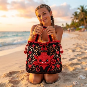 Puede incluir: Un bolso de mano tejido a ganchillo en negro y rojo con un personaje de diablo rojo central con cuernos, alas y cola negros. El bolso presenta un patrón de rejilla decorado con pequeños corazones y estrellas rojas, dos asas y un tridente.