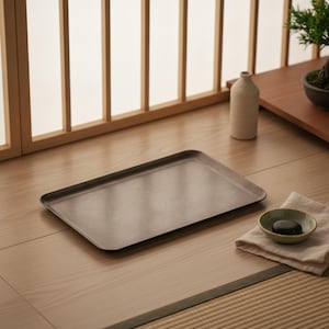 May include: A rectangular, dark brown serving tray with a smooth, matte finish and slightly raised edges. The tray is positioned horizontally, featuring a clean, flat surface with rounded corners, presenting a simple and functional design.