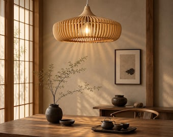 May include: A pendant light fixture featuring a wide, circular shade constructed from thin, light-colored wooden slats arranged in a vertical pattern. The fixture hangs from a single cord and contains a central light bulb that emits a warm glow.