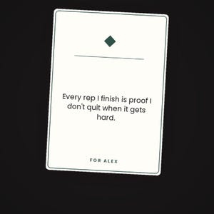 May include: A rectangular white card with a thin dark border featuring a dark green diamond icon above a horizontal line. The text reads: Every rep I finish is proof I don't quit when it gets hard. The bottom of the card includes the text: FOR ALEX.