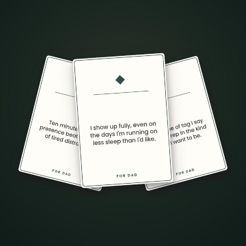 May include: Three white rectangular cards with rounded corners, each featuring black text and a small dark green diamond icon. The centre card reads, I show up fully, even on the days I'm running on less sleep than I'd like. All cards are labelled FOR DAD.