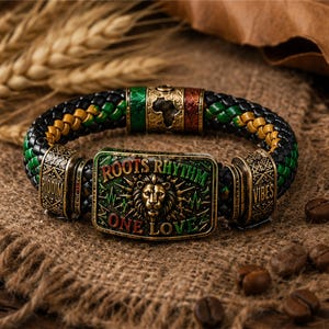 Può includere: Un bracciale intrecciato con fili neri, verdi e gialli con una piastra metallica rettangolare centrale che mostra una testa di leone, il testo ROOTS RHYTHM e ONE LOVE, e accenti metallici laterali incisi con le parole RIDDIM e VIBES.