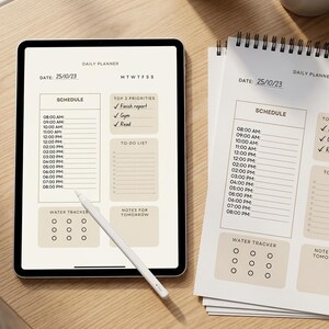 Peut inclure: Une tablette numérique et un bloc-notes en papier présentant un modèle de planificateur quotidien avec des sections pour l'emploi du temps, les priorités, la liste de tâches, le suivi d'eau et les notes. Un stylet blanc repose sur l'écran daté du 25/10/23.