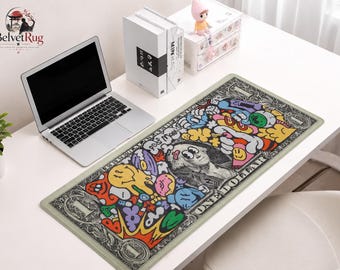 Pode incluir: Um tapete de secretária retangular com um design estilizado de nota de um dólar, com ilustrações coloridas de estilo graffiti sobrepostas aos gráficos clássicos da moeda, incluindo um retrato central e o texto ONE DOLLAR.