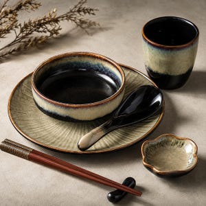 May include: A ceramic dinnerware set featuring a plate, a bowl, a cup, a spoon, a small flower-shaped dish, and a pair of chopsticks. The pieces have a reactive glaze finish with a gradient of dark brown, black, and light beige tones.