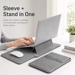 Könnte beinhalten: Eine graue Laptoptasche, die sich in einen Ständer verwandelt und einen silbernen Laptop trägt, mit einer weißen kabellosen Maus auf der integrierten Matte. Text: Sleeve + Stand in One. Folds into a stand in seconds for comfortable working and better airflow.
